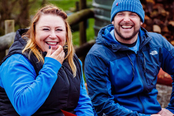 Two people wearing outdoor clothing, smiling at the camera