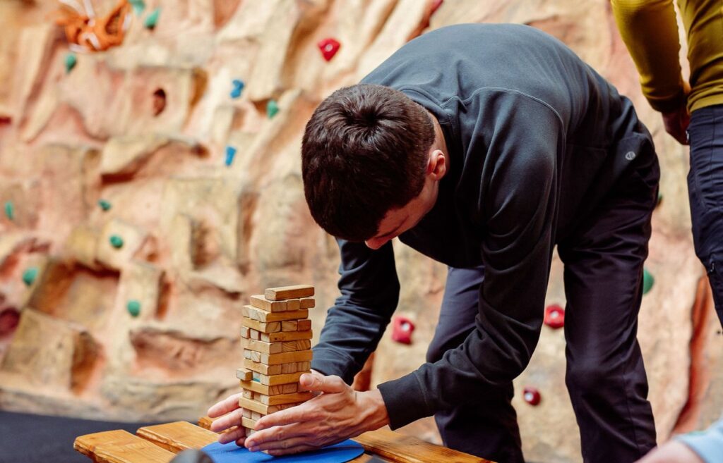 A person carefully balances a tower of jenga blocks